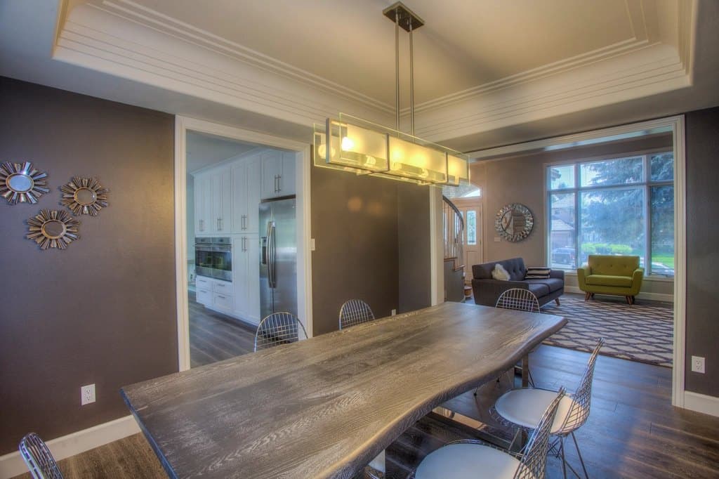 Open-plan dining area with a pendant light over a wooden table