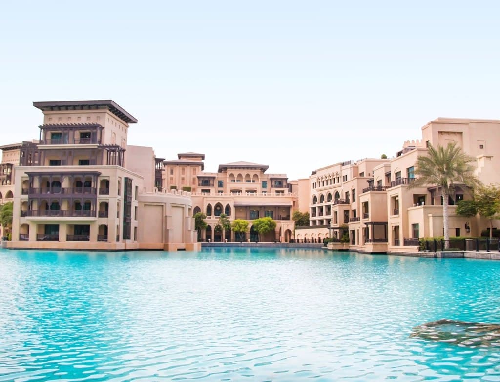 Traditional-style buildings and palm trees beside the water in Downtown Dubai