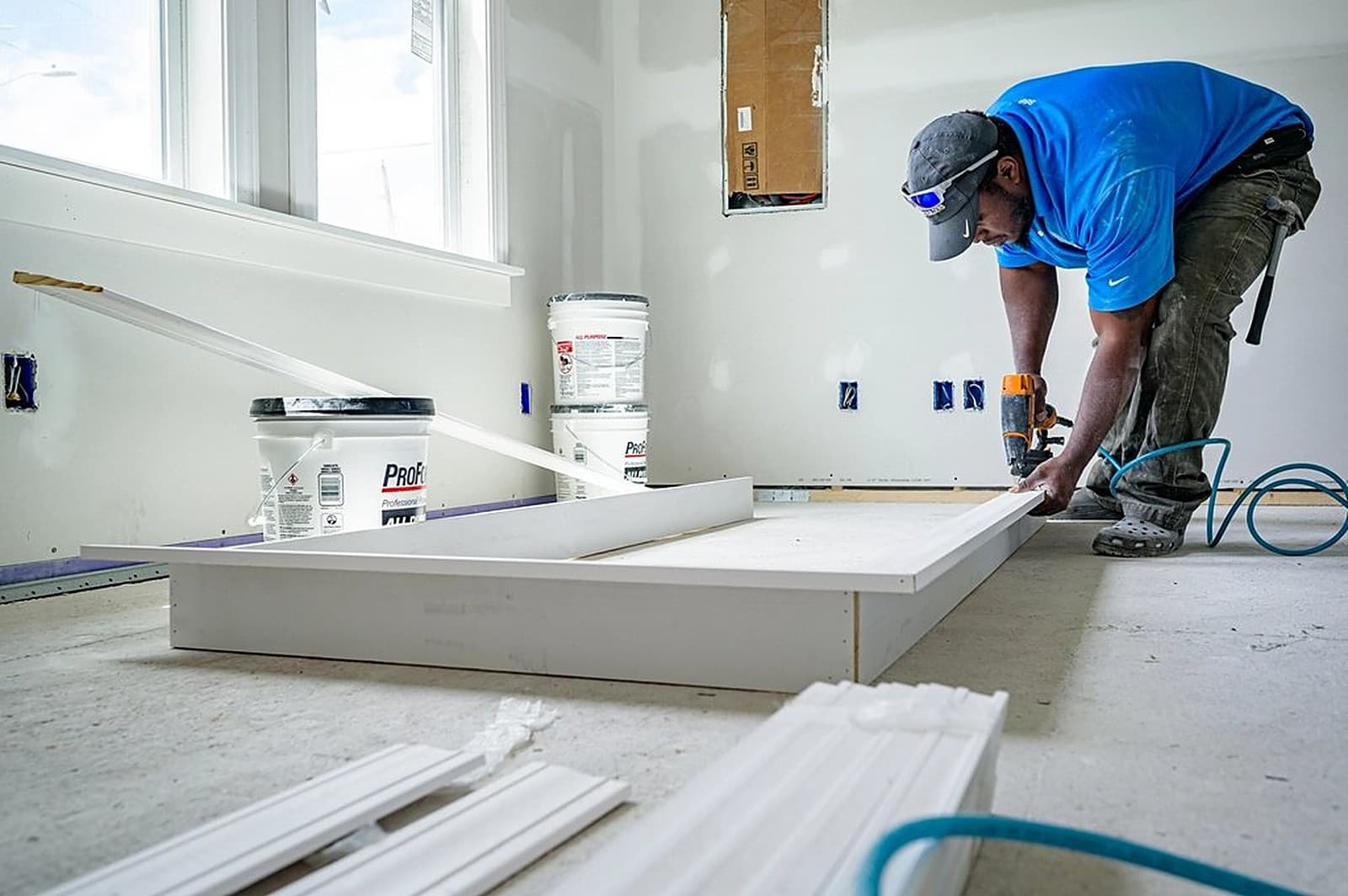 Maintenance technician carefully fitting interior trim in a bright room