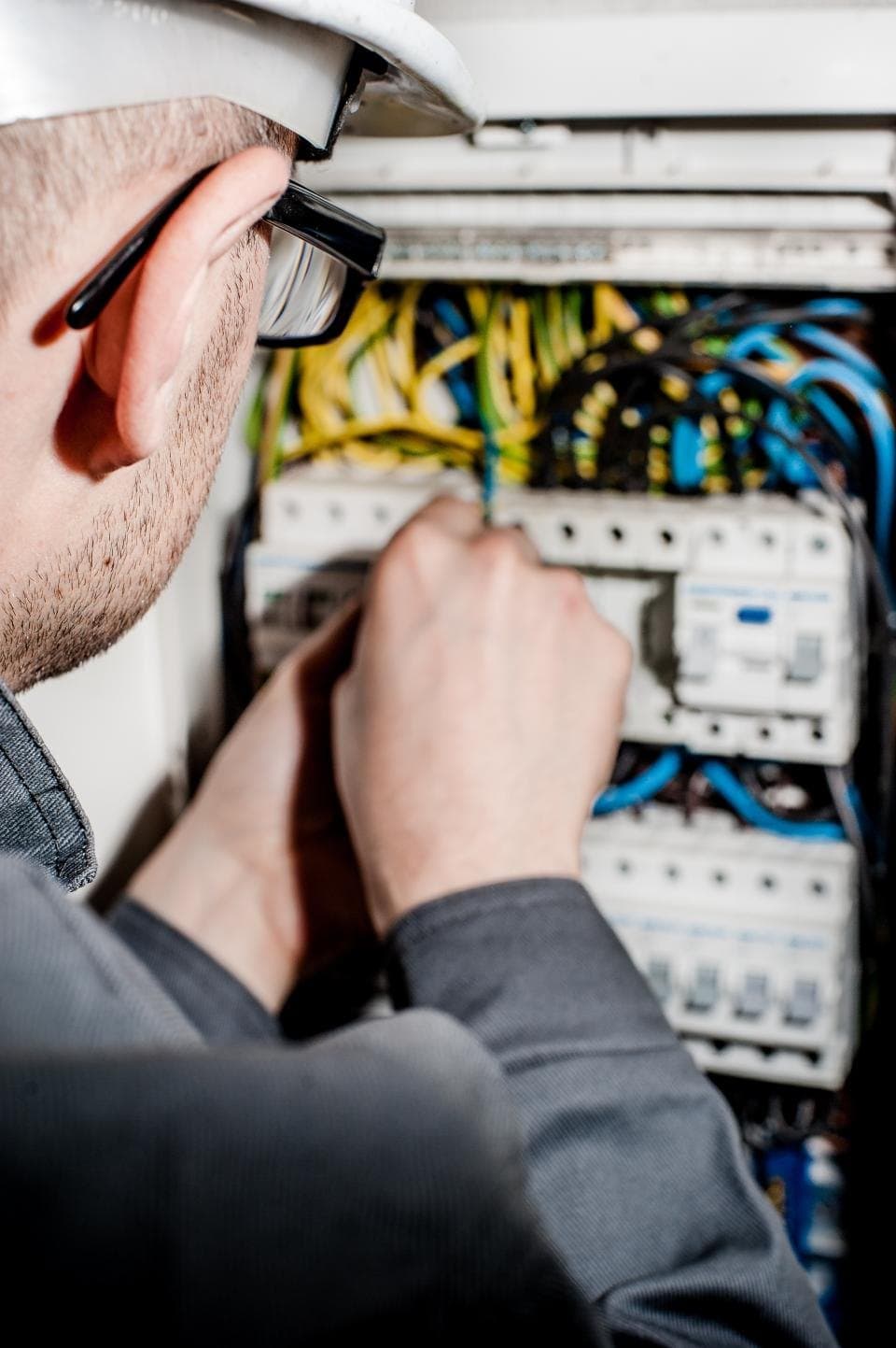 Electrician checking circuit breakers inside a distribution board