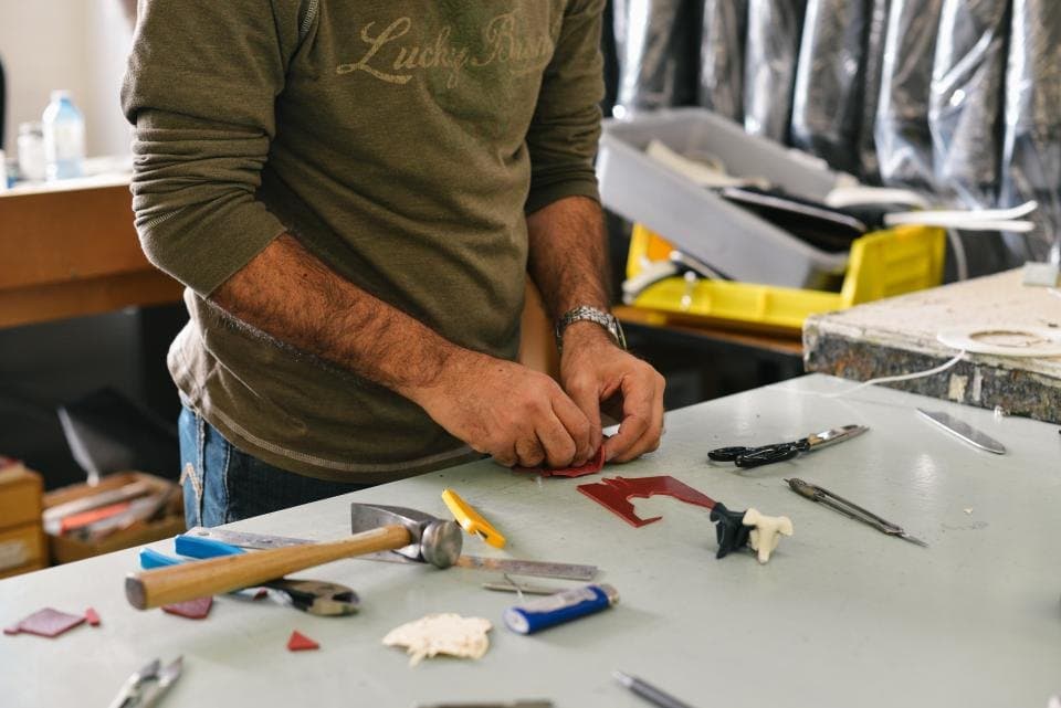 Technician repairing a fitting at a workbench