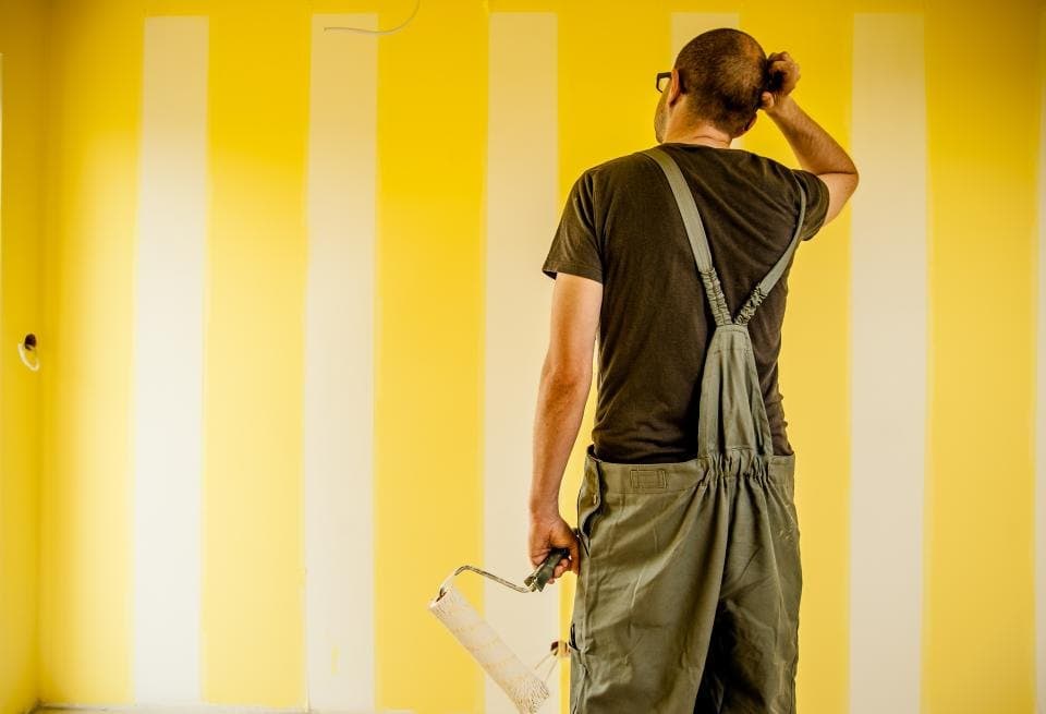 Painter reviewing a freshly painted interior wall